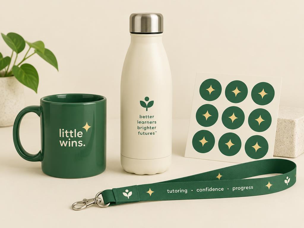 Little Wins branded green mug, cream water bottle, sparkle stickers, and lanyard